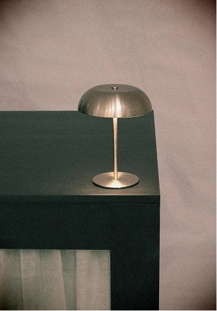 Brass table lamp on a dark green counter